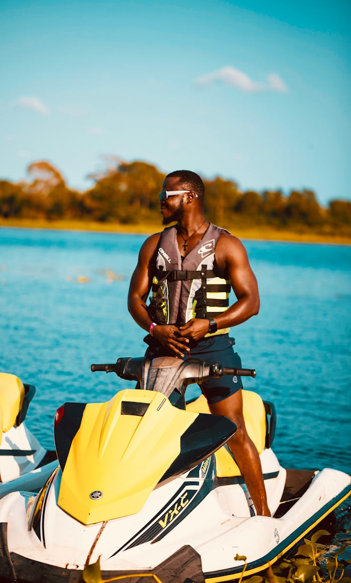 A man in sunglasses on a jet ski in Ada Foah, Ghana during summer.